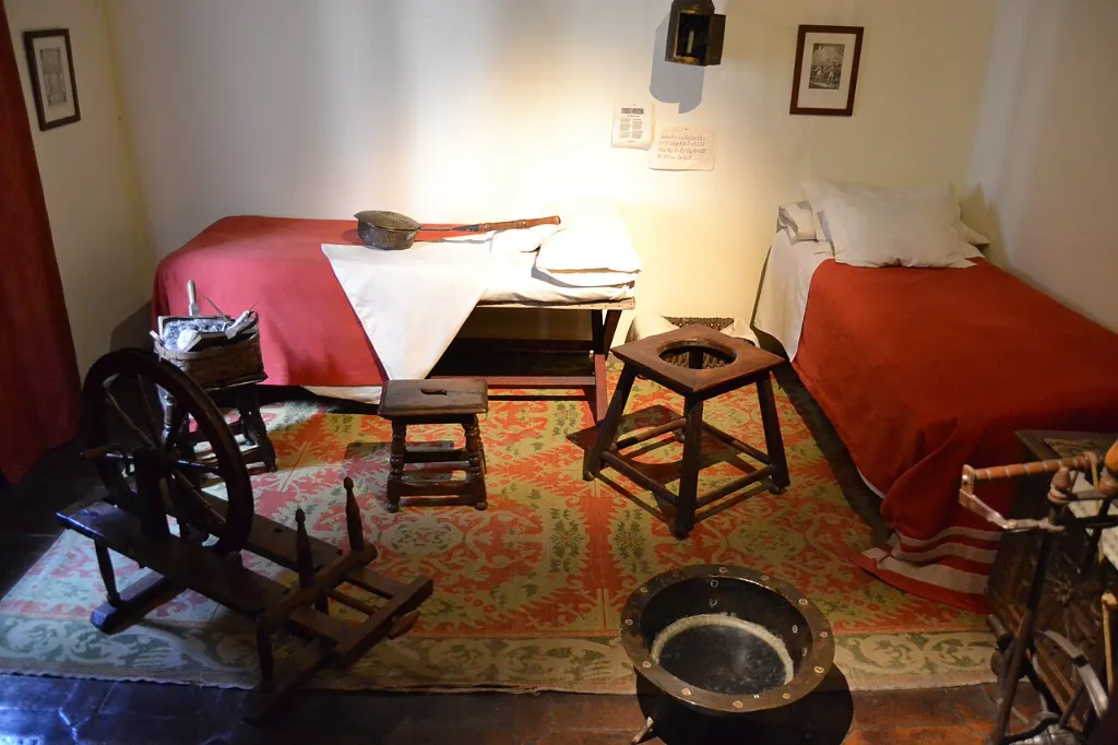 Alcoba con camas, rueca y brasero en la planta alta de la Casa Natal de Cervantes