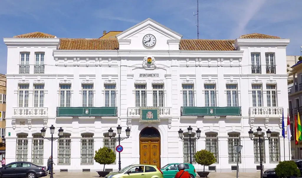 Fachada blanca del Ayuntamiento de Tomelloso con su reloj, en la Plaza de España