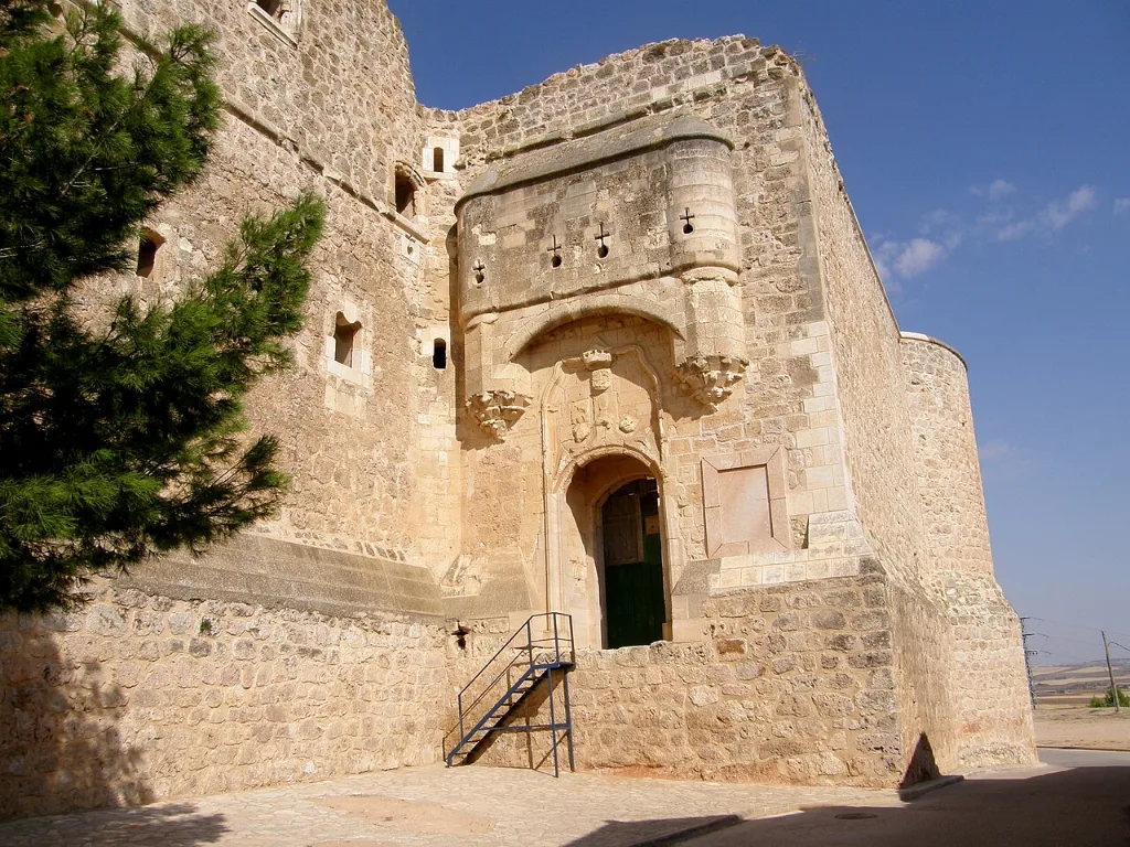 Portada gótica del castillo de Garcimuñoz entre torres de piedra