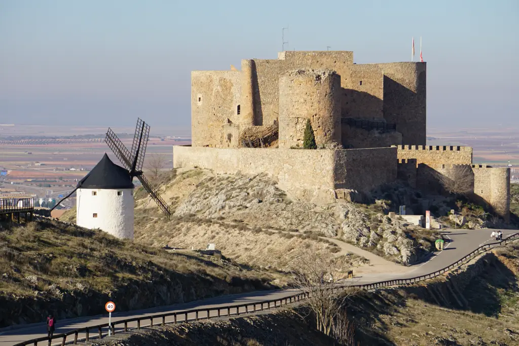 Torres y murallas del castillo de Consuegra junto a un molino de viento