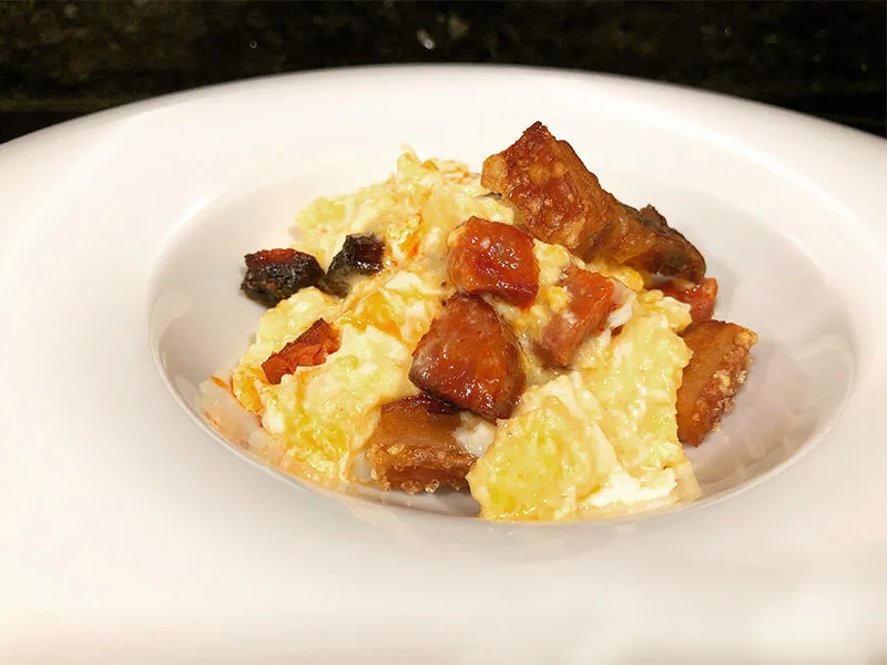 Plato de duelos y quebrantos: huevos revueltos con dados de tocino y chorizo