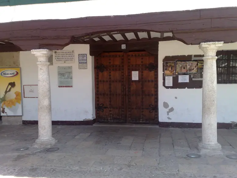 Puerta de madera de entrada al Corral de Comedias de Almagro entre dos columnas de piedra
