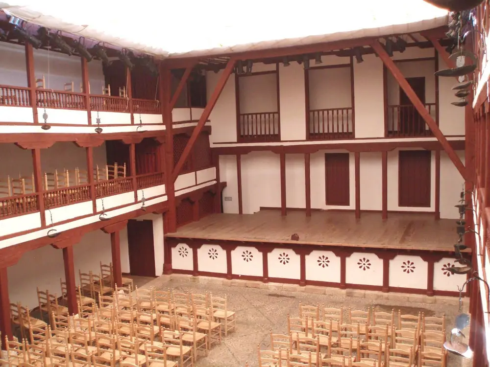 Tablado, patio con sillas de madera y corredores del Corral de Comedias de Almagro