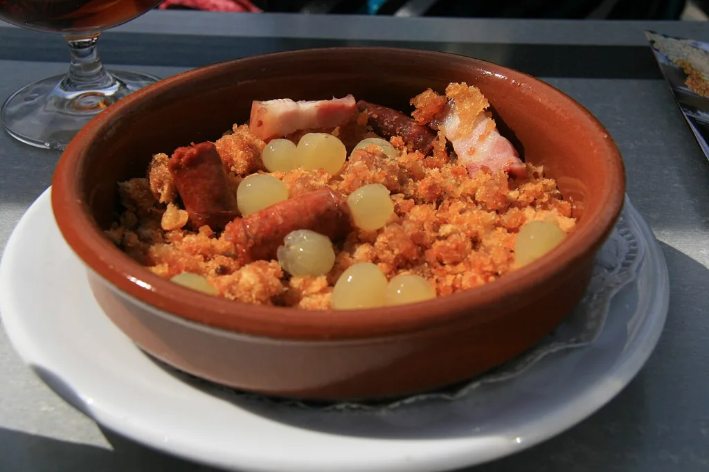 Cazuela de barro con migas, uvas blancas y chistorra