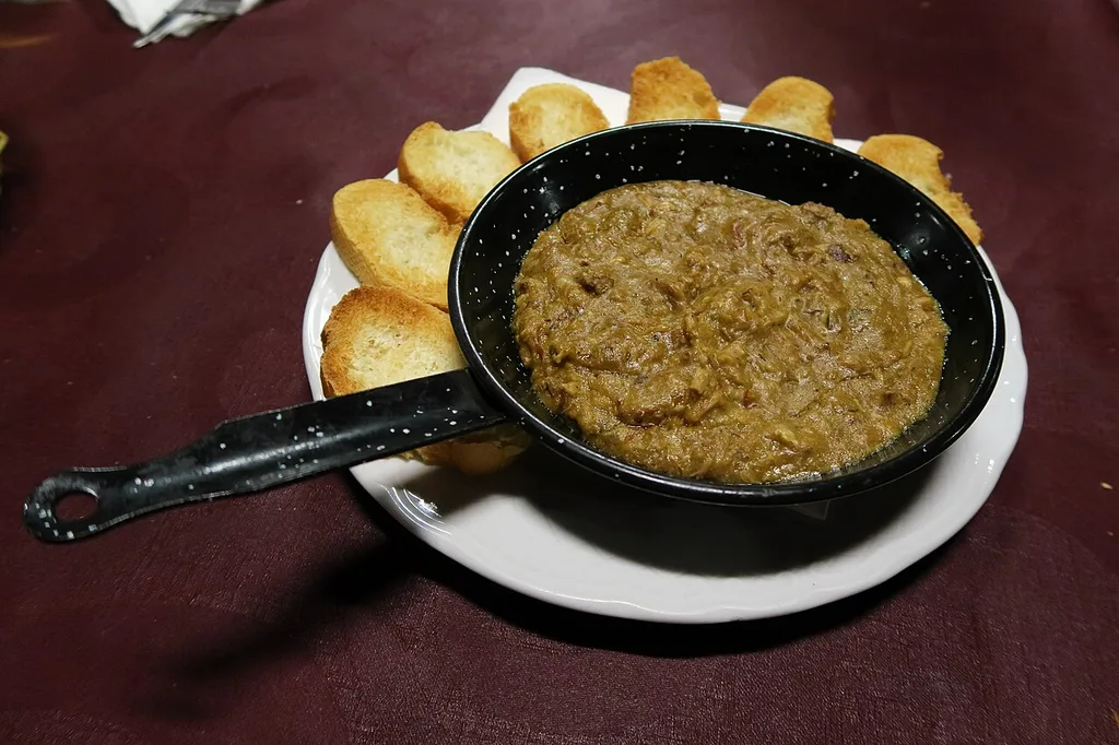 Morteruelo de Cuenca servido en sartén con pan tostado