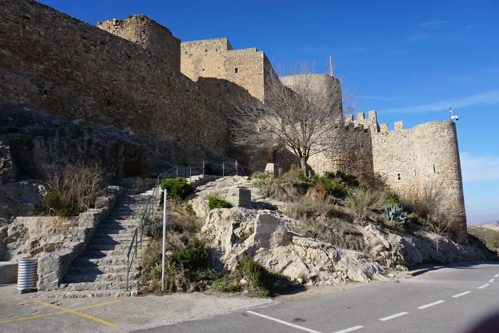 Murallas y torre redonda del castillo de Consuegra con la escalera de subida desde el aparcamiento