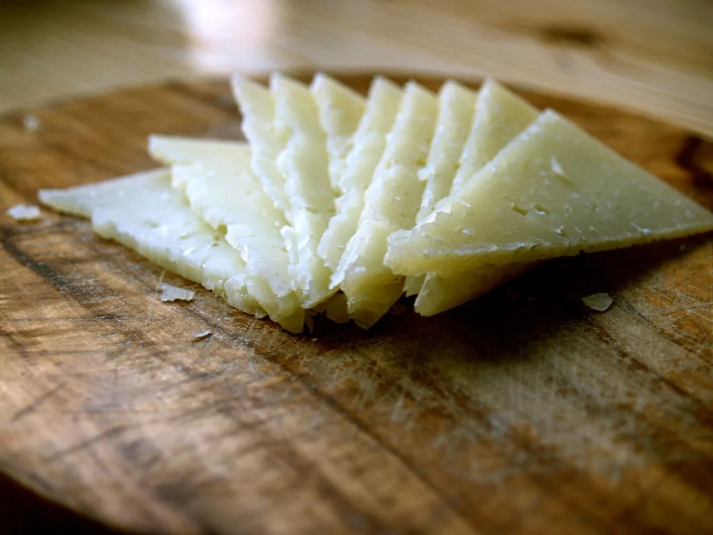 Cuñas de queso manchego curado sobre una tabla de madera